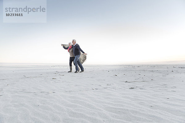 Südafrika  Kapstadt  Seniorenpaar zu Fuß am Strand