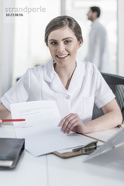 Porträt der lächelnden Krankenschwester beim Klinikempfang