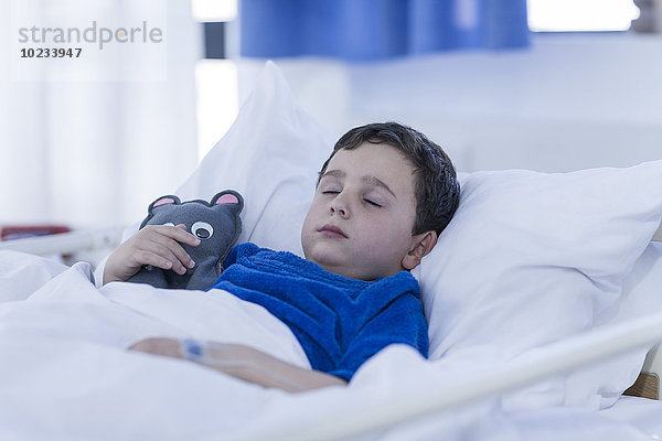 Porträt eines kleinen Jungen  der in einem Krankenhausbett schläft