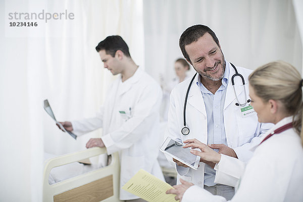 Ärzte mit digitalem Tablett im Krankenhauszimmer