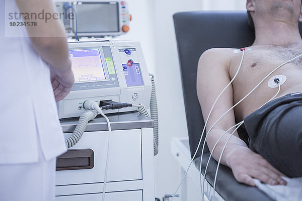 Junger Mann im Krankenhaus mit Herzfrequenzüberwachung