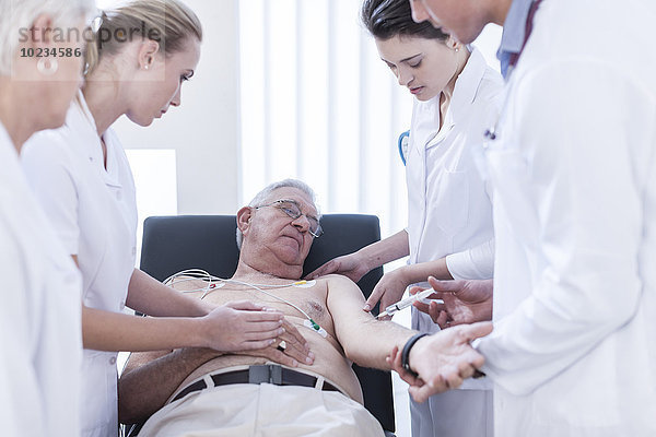 Ein älterer Mann im Krankenhaus bekommt eine Spritze.