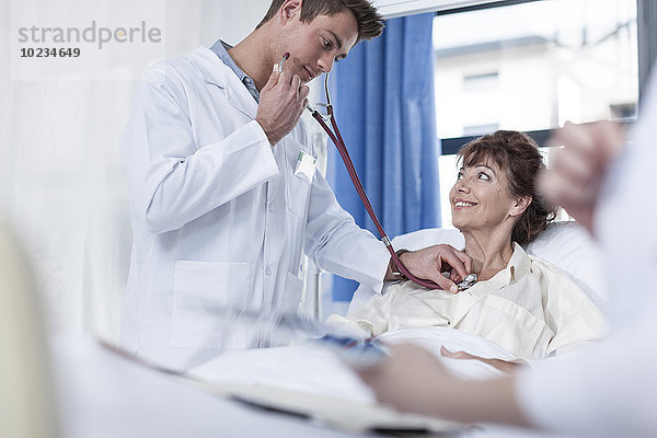 Arzt untersucht Frau im Krankenhausbett