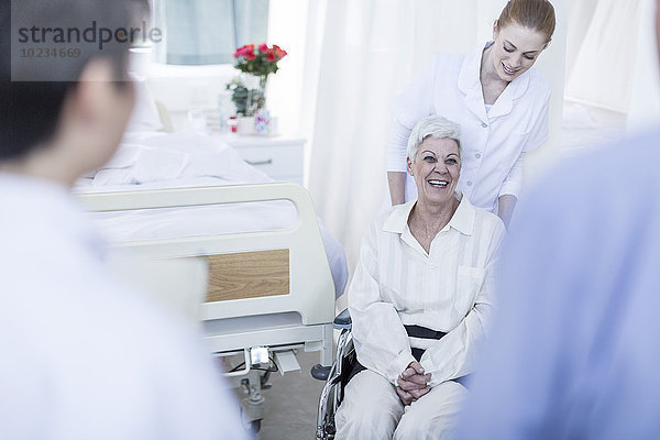 Krankenschwester mit älterer Patientin im Rollstuhl