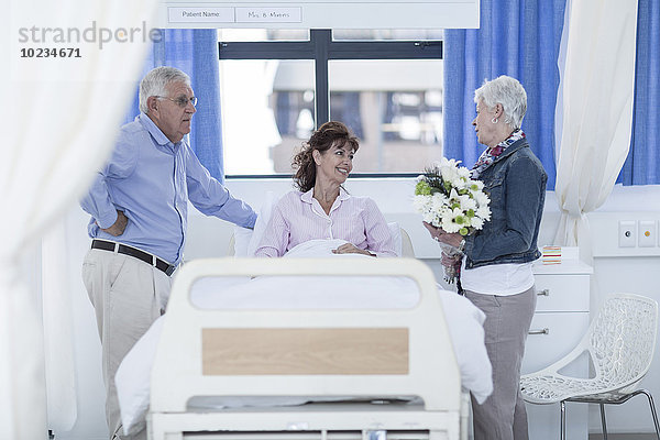 Seniorenpaar besucht reife Patientin im Krankenhaus