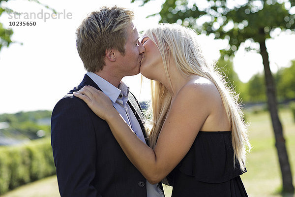 Elegantes junges Paar beim Küssen im Freien