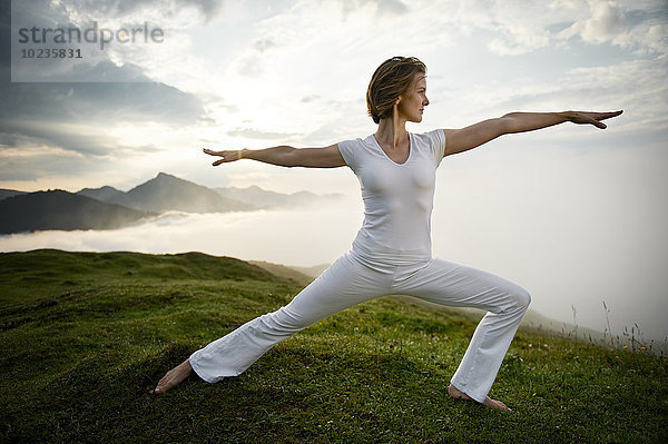 Österreich  Kranzhorn  Mittlere erwachsene Frau beim Yoga auf dem Berggipfel