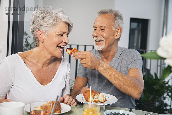 Älteres Paar beim Frühstück auf dem Balkon