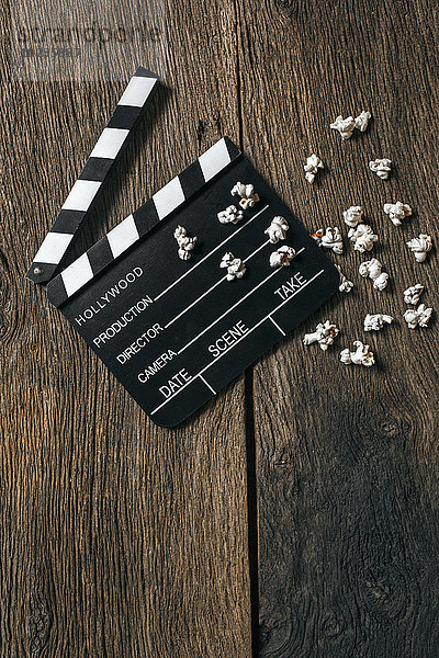 Filmklapper und Popcorn auf altem Holz