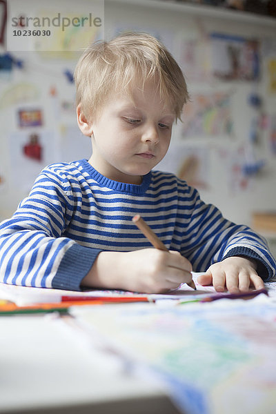 Porträt eines blonden kleinen Jungen mit Buntstift