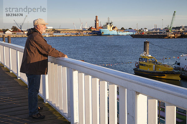 Deutschland  Niedersachsen  Cuxhaven  Senior am Hafen mit Blick auf den Hafen