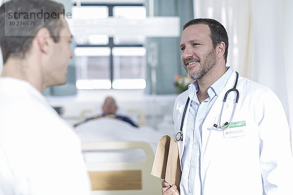 Zwei Ärzte sprechen in einem Krankenhauszimmer