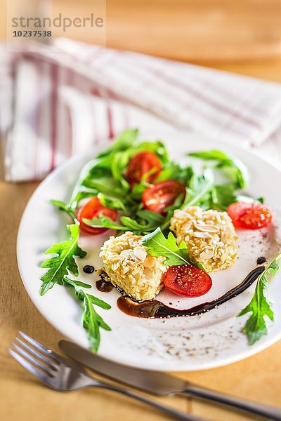 Salat mit Ziegenkäse in der Mandelkruste  Rucola  Tomaten und Balsamicosauce
