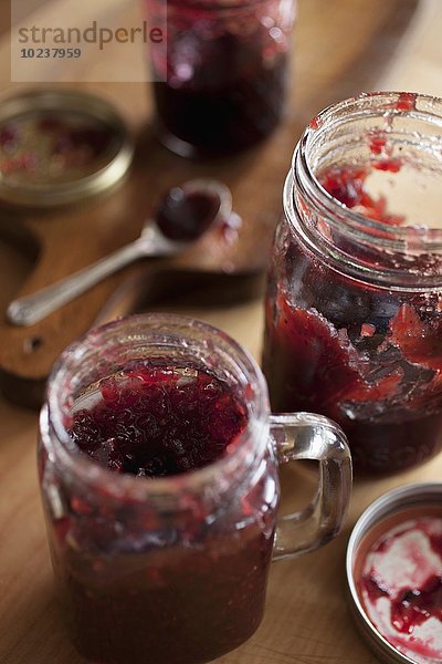 Heidelbeer-Erdbeer-Marmelade in Gläsern auf Holztisch