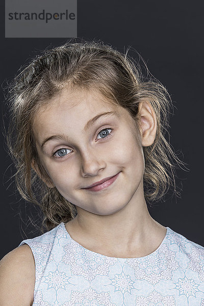 Porträt des glücklichen Mädchens über grauem Hintergrund