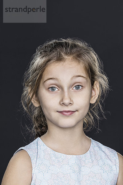 Porträt des selbstbewussten Mädchens über grauem Hintergrund