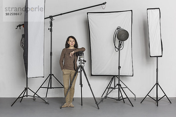 Volle Länge der selbstbewussten reifen Fotografin im Fotostudio