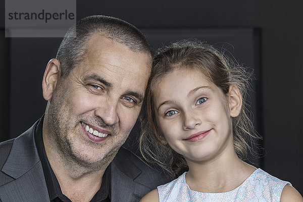 Nahaufnahme des glücklichen Vaters mit Tochter über grauem Hintergrund