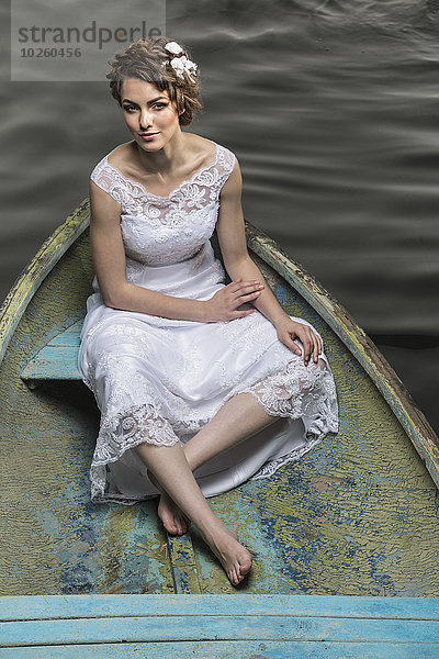 Hochwinkelporträt einer jungen Braut im Boot auf dem See