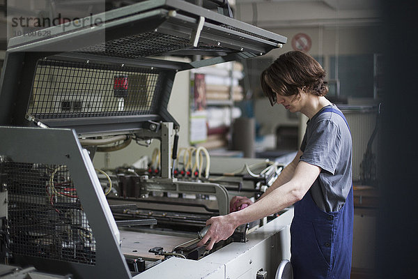 Seitenansicht der jungen Handarbeitermaschine in der Fabrik