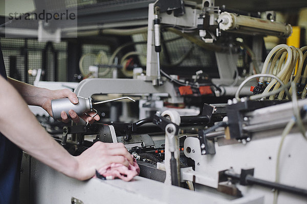Beschnittenes Bild der manuellen Arbeiter-Ölmaschine in der Fabrik