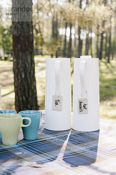 Krüge und Becher auf dem Tisch im Wald