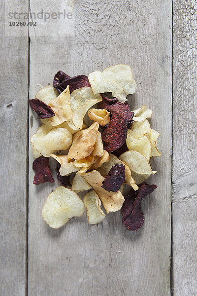 Direkt über Schuss Kartoffel- und Rote-Beete-Chips auf Holztisch