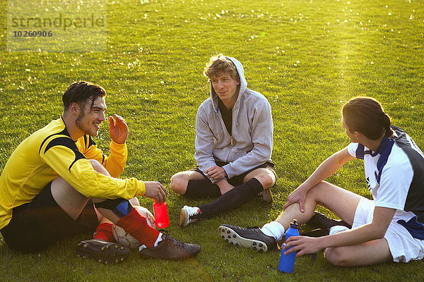 Junge Fußballspieler entspannen sich auf dem Spielfeld
