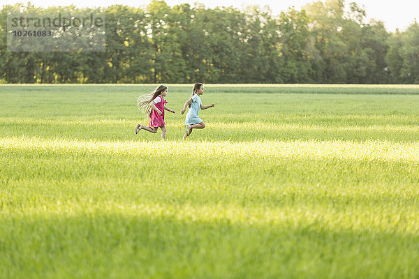 Seitenansicht von Mädchen  die auf einem Grasfeld laufen