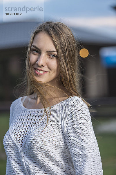 Porträt einer schönen jungen Frau  die im Freien lächelt.