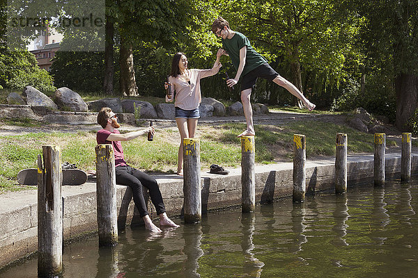 Glückliche Freunde genießen am Kanal im Park