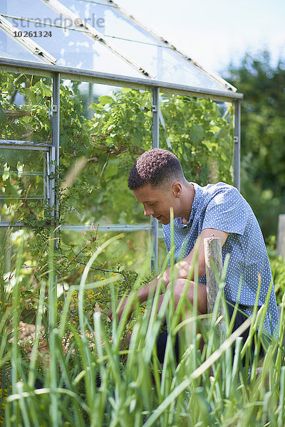 Junger Mann Gartenarbeit im Park