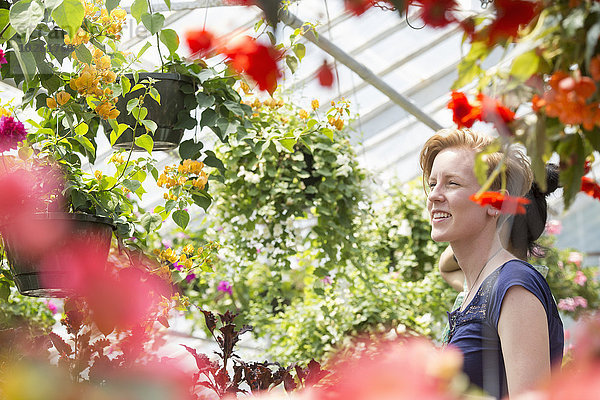 junge Frau junge Frauen sehen Blume Korb hängen bunt Pflanze Garten