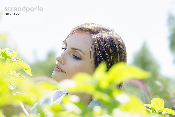 Außenaufnahme junge Frau junge Frauen grün Pflanze umgeben freie Natur