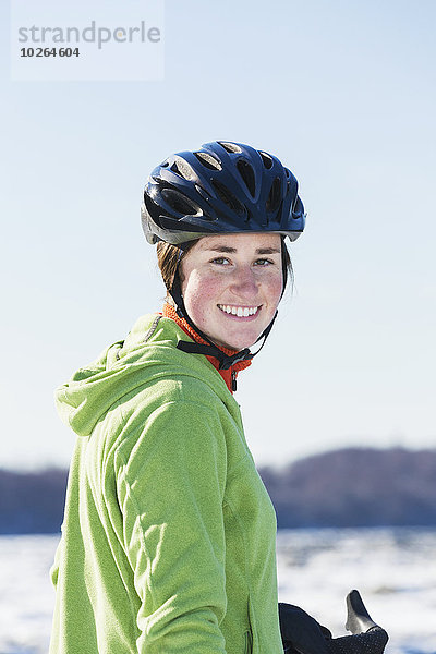Vereinigte Staaten von Amerika USA junge Frau junge Frauen Portrait Winter lächeln schwarz Kleidung Fahrrad Rad Helm