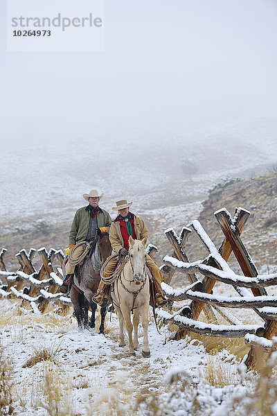 Vereinigte Staaten von Amerika USA nebeneinander neben Seite an Seite Zaun Rocky Mountains Cowgirl Schnee
