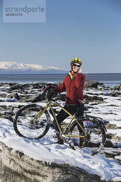 Handy stehend junge Frau junge Frauen sprechen folgen Küste Eis vorwärts Fahrrad Rad Stück gefroren