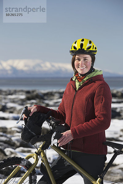 stehend junge Frau junge Frauen folgen Küste Eis vorwärts Fahrrad Rad Stück gefroren