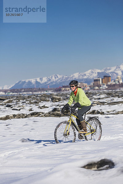 Vereinigte Staaten von Amerika USA junge Frau junge Frauen folgen Küste Eis Fahrrad Rad Schnee