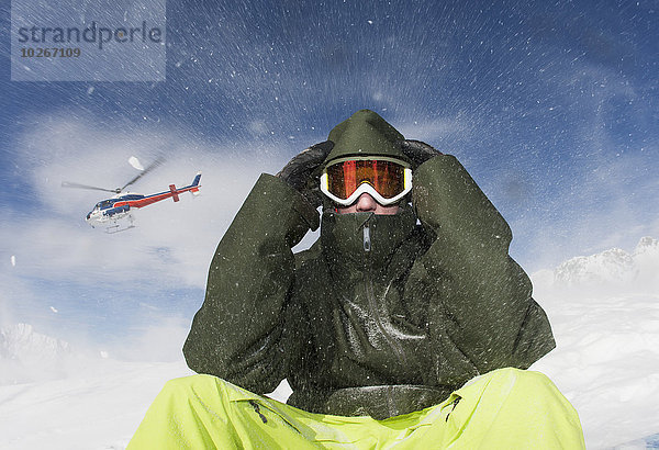 Winter Mann Kleidung sitzend blasen bläst blasend über Ski jung Hubschrauber Maske Schnee