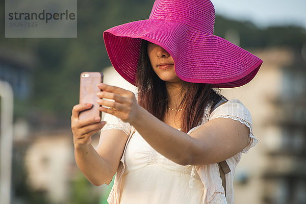 Handy junge Frau junge Frauen Portrait nehmen Hut pink groß großes großer große großen Einsamkeit China Fujian Xiamen