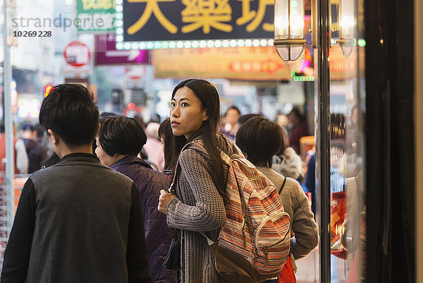 Rucksack zwischen inmitten mitten junge Frau junge Frauen Straße beschäftigt vorwärts Fußgänger Größe China Hongkong