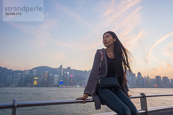 sitzend Skyline Skylines junge Frau junge Frauen Sonnenuntergang Ufer Hintergrund Geländer