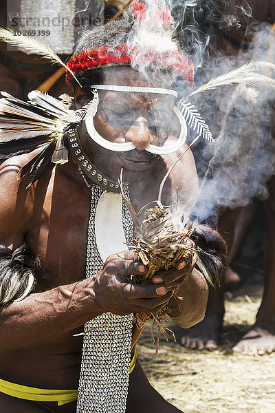 beleuchtet Mann Kopfschmuck Feuer Vogel Kleidung Mittelpunkt Komplexität Kasuar Guinea Indonesien Paradies