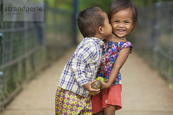 Junge küsst ein junges Mädchen; Battambang  Kambodscha