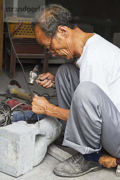 Handwerker beim Schnitzen eines Steinlöwen  Xidi  Anhui  China