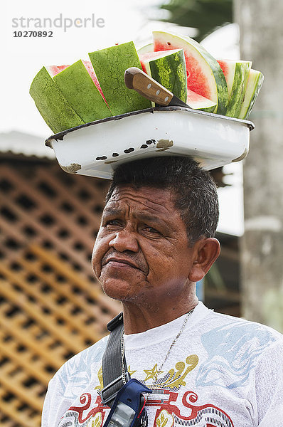 Mann trägt ein Tablett mit aufgeschnittenen Wassermelonenstücken auf dem Kopf  San Jacinto de Yaguachi  Guayas  Ecuador