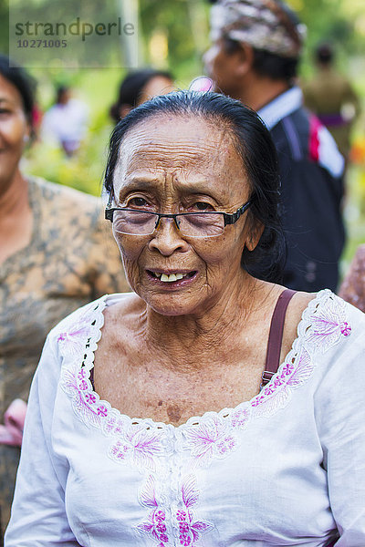 Ältere Frau bei einer Ngaben- oder Einäscherungszeremonie  Klungkung  Bali  Indonesien