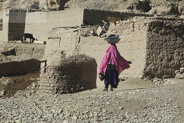 Frau trägt Wäsche auf ihrem Kopf in einem Dorf im Aqrabat-Tal  Provinz Bamian  Afghanistan