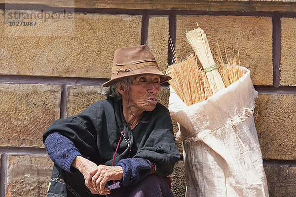 Besenverkäufer an der Wand sitzend  Sucre  Departement Chuquisaca  Bolivien